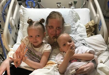 Picture of Alayla in hospital with two children 