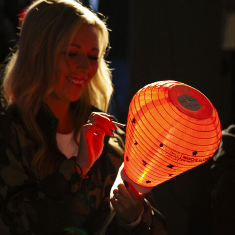 Woman smiling while decorating her red lantern